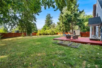 Looking across the yard, you’ll see multiple options for outdoor fun, from gardening in raised beds to lounging on the deck—all with privacy and shade from surrounding trees.