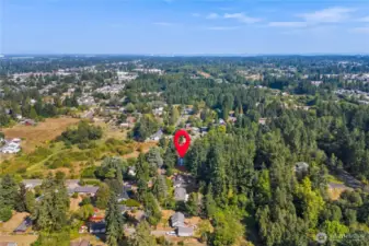 Wide aerial with location marker pinpointing the home, offering perspective on its proximity to open fields, surrounding residences, and tree-lined streets—ideal balance of privacy and neighborhood connection.