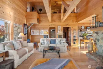 Living room reflects soothing natural light onto wood beams and wood features. River stone hearth and Log mantle warm you with propane fireplace to entertain comfortably.