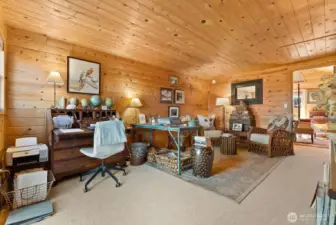 Pine wood tongue & groove paneling and wall to wall carpet in the loft Den Office area. Window door and stairway that leads to the North deck.