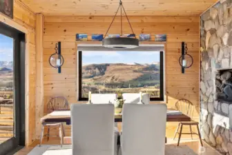 Dining Room off the South deck and next to Kitchen for easy serving meals to your friends, family and guests alike. Stone & wood together with big mountain views are ready for your decoration each Holiday!      Dining room conveniently located next to Kitchen and by South deck, is a place that you will enjoy long leisurely meals with friends, family and guests alike. Charming stone and wood creates perfect ambiance with endless mountain views with great company. Hardwood floor.