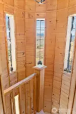 Indoor Stairs craftsman in turret that extends to each level of this home. Carpeted stairs, railing and wood wall beauty.