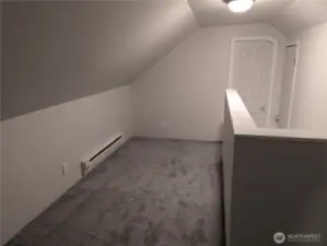 Hallway between upstairs bedrooms with space for a couch and a entertainment nook