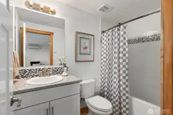 Downstairs full bath with tile surround and granite.