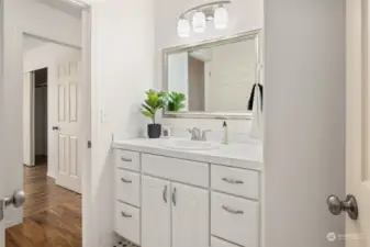 Main bath with tiled counter tops with separate shower/toilet area.