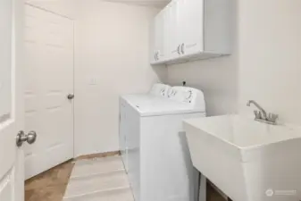 Spacious laundry room with soaking tub and extra storage