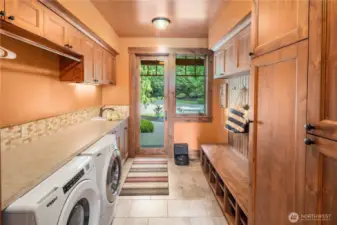 If kids, dad, or anyone gets muddy outside, no problem! Enter through a separate door, and drop the clothes in the washer. The additional cabinet space, shoe storage and coat / backpack hangers keep your daily use items in order. The closet to the right even has power inside for vacuum, and other utility items. But wait! There is more! To the left... the laundry chute! Clothes drop from the upper bedrooms, right next to the washer. This home was truly thought out by every room. This is custom.