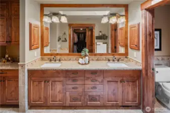 Large double vanity, additional storage & prep space to the left, and a private water closet to the right. Huge walk-in closet is behind, shower to the left.