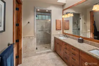 Spa-inspired en-suite bath with dual vanity sink, radiant heated floors, skylight & under-counter lighting, and a separate water closet. Spacious walk-in closet