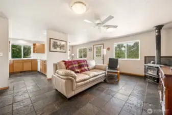 This family room serves up textured slate floors, crisp white walls, and breezy vibes courtesy of the ceiling fan. Bonus: the open line of sight into the kitchen and dining area means you can keep an eye on everything.