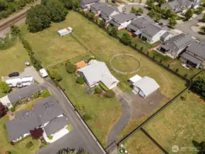 Space to roam! From this aerial view, spot the round pen perfect for your equine friends, the extra-long driveway tucked behind the manual gated entry, and all the room to live your best life.