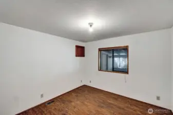 Guest bedroom on East side of the home has window view to carport area.