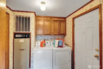 Large utility room has washer and dryer, storage cabinets and room for freezer or other necessities.