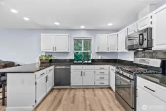 Stunning updated kitchen with granite counters, undermount sink and stainless steel appliances. Cabinets are beautifully refreshed with new paint and hardware.