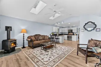 This view from the living room shows the newer skylights (2022) looking into the kitchen. The hallway and primary suite are to the right beyond the chair.
