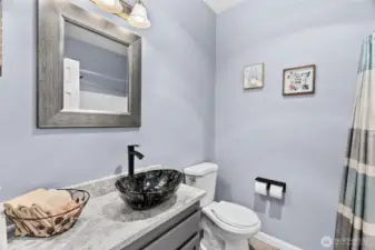 Updated 2nd bathroom with bath/shower combo with new rainfall shower head, pretty quartz vanity and new toilet.