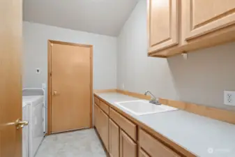 Laundry area with sink and cabinets and folding are.