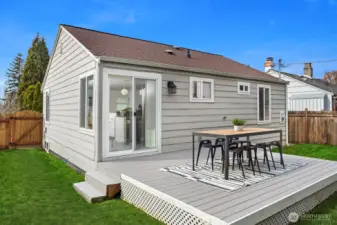 A gorgeous deck and tons of space to roam in this backyard!