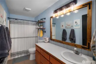 This clean and functional main bathroom offers updated fixtures and easy-to-clean surfaces.
