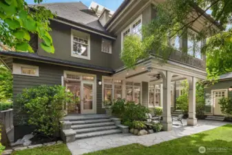 Professionally designed gardens define the property in luxurious established green. Here, French doors offer a gracious extension of the kitchen and sunroom.