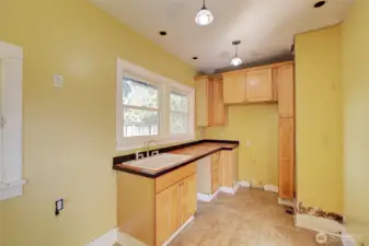 This kitchen was upgraded at one point. Add appliances and your ready to cook. (the discoloration on the right above the trim looks like glue in person).