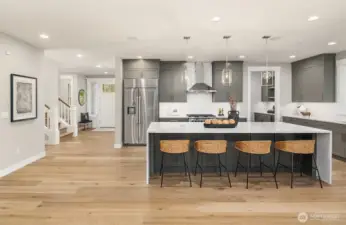 Huge center island with accent cabinet color & waterfall quartz top