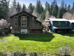 View of the back of the house, the ADU over the garage, and shops. The fenced in garden is below the house.