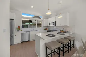 This modern kitchen features beautiful, crisp white cabinetry paired perfectly with high-end stainless steel appliances. The sleek, contemporary design is accented by soft-close cabinets and engineered hardwoods, creating a space that is as functional as it is stylish.