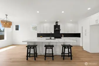 Sleek white cabinets offer storage galore. Soft close doors & drawers. Recessed can lighting, custom chandelier, black and stainless appliances blend the space.