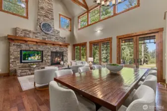 Open-concept floorplan with expansive windows framing golf course views, bathed in natural light and embraced by lush, surrounding landscape.