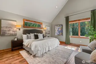 Sophisticated upper-level master with soaring arched ceiling, rich knotty-pine hardwood floors, and solid wood doors. Built-in, recessed chest of drawers adds bespoke, high-end functionality, while a personal thermostat ensures comfort tailored to your preference.