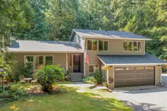 The home’s inviting entry is complemented by vibrant landscaping. The covered steps and thoughtfully placed lighting create a warm welcome for you and your guests.