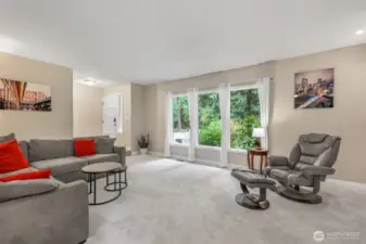 Large windows along the front of the home create a seamless connection with the outdoors. Whether relaxing or entertaining, this space balances comfort with functionality.