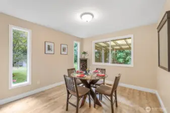 The dining area is designed for both casual meals and special occasions. Natural light streams through multiple windows, offering peaceful views of the surrounding greenery.