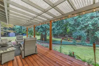 Step outside to a covered back deck that overlooks the expansive backyard. With plenty of space for seating and year-round use, this area is perfect for outdoor living and entertaining.