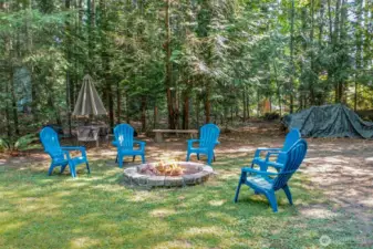 A stone firepit creates the perfect spot for evenings under the stars. Surrounded by evergreens, it’s an inviting space to relax or entertain in every season.