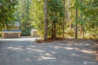 The large driveway leads to the two-car garage with additional space for parking. A detached shed provides extra storage, adding to the property’s functionality.