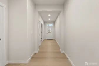 Entryway featuring hardwood floors extended through hallway.