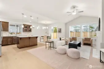 Light and bright open living room with vaulted ceilings and ceiling fan.