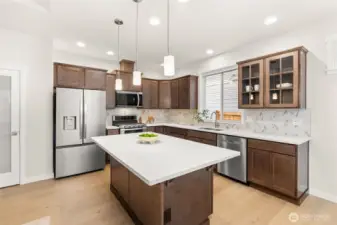 Kitchen features Cocoa-stained Maple Cabinets and Quartz countertops. Whirlpool stainless steel gas double oven is standard. This home also features a French door refrigerator.