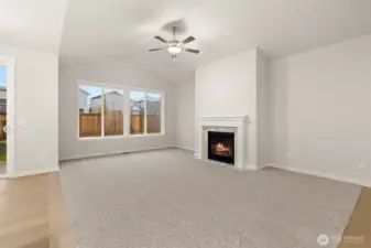 Light and bright open living room with vaulted ceilings and ceiling fan.