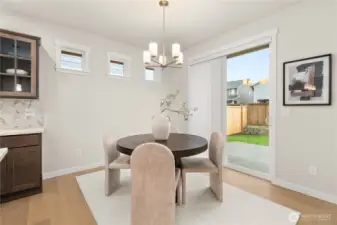 Dining area features hardwood flooring and a glass slider that opens to backyard and patio area.