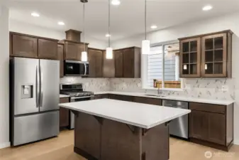 Kitchen features Cocoa-stained Maple Cabinets and Quartz countertops. Whirlpool stainless steel gas double oven is standard. This home also features a French door refrigerator.