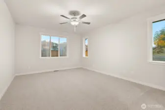 Large primary bedroom featuring a standard ceiling fan for comfort.