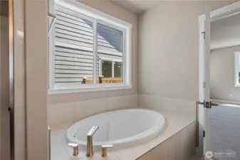 Primary bath also offers a beautiful, large soaking tub with tile surround.