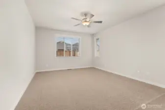 Large primary bedroom featuring a standard ceiling fan for comfort.