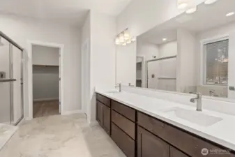 Primary bath is stunning with a double vanity with undermount sinks and tile backsplash.