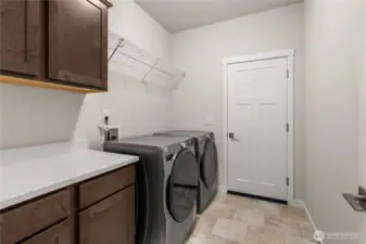 Separate laundry room with a counter, storage cabinets and a storage shelf above appliances. Washer and Dryer are included.