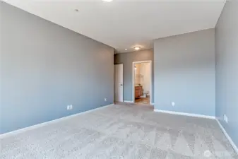 Large primary bedroom with spacious attached bathroom and custom closet