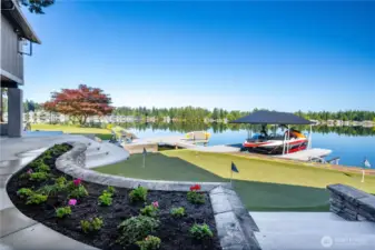 Side yard perspective of the 4 hole putting green and the two docks connected by the bridge Both the boat and jet ski lifts are solar powered